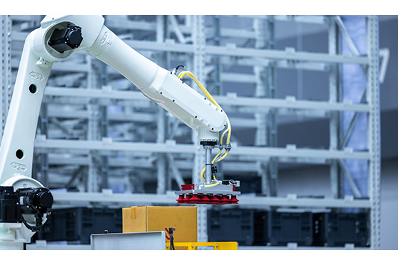 Robotic arm handling boxes on pallets in an automated warehouse